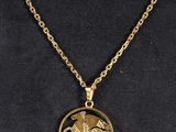 a gold necklace with a horse and rider on it