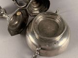 a silver tea pot and a silver tea pot on a table