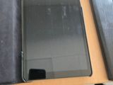 une tablette posée sur un bureau, à côté d'un ordinateur portable