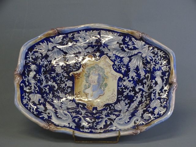 SAINT CLEMENT. Plat ovale chantourné en faïence à décor d’heaume ...