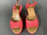 a close up of a pair of pink shoes on a gray surface