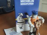 une petite figurine représentant un homme tenant une batte de baseball, posée sur une table