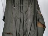 an image of a jacket hanging on a hanger on a bed