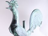 a statue of a rooster that is standing on a pedestal
