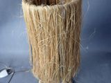 a tall vase with a bunch of straw in it