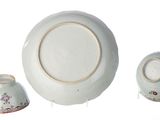 three pieces of porcelain sitting on a white surface