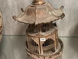 a birdcage with a bird inside of it on display
