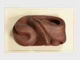a wooden sculpture of a face on a white surface
