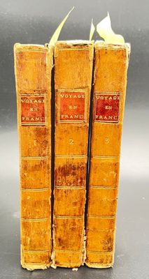 three old books are stacked on top of each other on a table