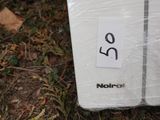 a white refrigerator sitting on the ground in the grass