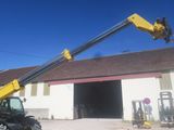 a picture of a man on a crane in front of a building