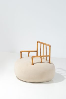 une image représentant une chaise posée sur un coussin, sur une surface blanche