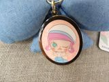 someone is holding a keychain with a picture of a girl on it