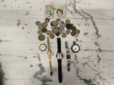beaucoup de pièces de monnaie et une montre posées sur une table en marbre