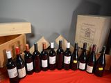 several bottles of wine are lined up on a red table cloth