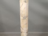 a white marble pedestal with a marble top on a gray background
