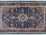 un tapis oriental à fond bleu et bordure rouge
