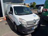une camionnette blanche garée sur un parking à côté d'un bâtiment