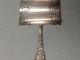 a silver spoon and spoon rest on a wall