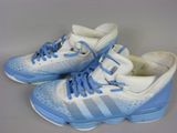 adidas shoes with blue laces and white soles on a gray surface