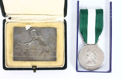 an old silver medal with a green ribbon in a box
