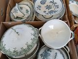 de nombreux bols et assiettes dans une boîte posée par terre