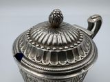 a silver container with a lid on a table