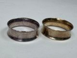 two silver rings sitting next to each other on a white surface