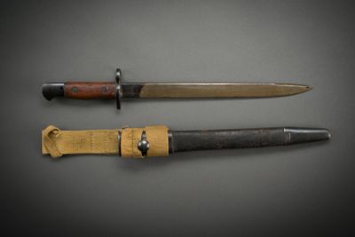 two knives are shown on a gray surface with a black background