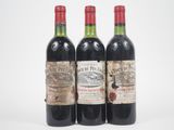 trois bouteilles de vin rouge posées l'une à côté de l'autre sur une surface blanche