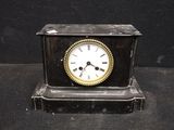 a small clock that is sitting on a black table
