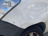 a white car that has a dent in the front of it