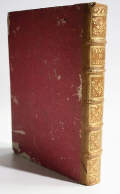 an old book sitting on top of a white table next to a white wall