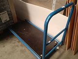 a blue cart with a sheet on it in a warehouse