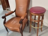a brown leather chair and a stool in a room