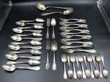 a lot of silver spoons and spoons on the table