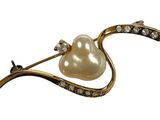 une image représentant une broche en perles et diamants sur fond blanc