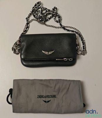 une image représentant un sac à main noir muni d'une chaîne argentée