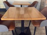 des tables et des chaises dans un restaurant, avec un tableau accroché au mur derrière elles