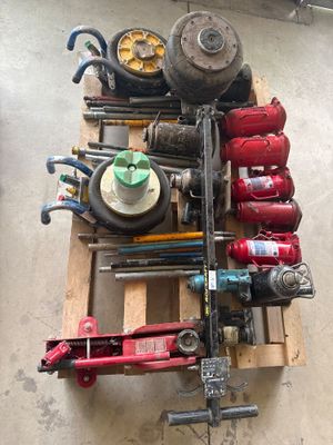 un tas d'outils posés sur une palette dans un garage