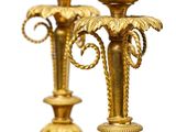 two gold vases sitting on a table with a white background