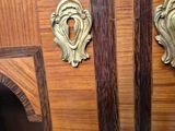 a wooden cabinet with two brass handles on it