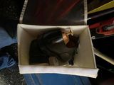 a pair of black shoes in a box on the ground