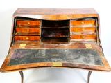 un vieux bureau avec un plateau en cuir et des tiroirs