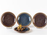 three plates that are sitting on a plate stand