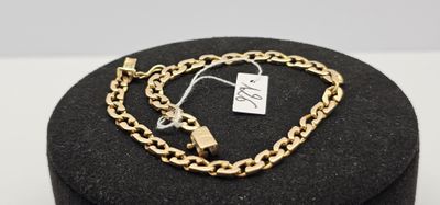 un gros plan sur un bracelet en chaîne dorée orné d'un cadenas