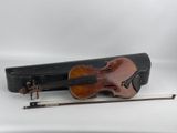 un vieux violon posé sur un étui en bois, à côté d'une corde