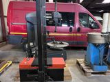 a red van parked in a warehouse with a red van in the background