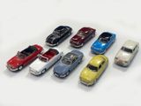 several toy cars are lined up in a row on a white surface