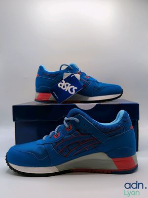 a pair of blue and red sneakers sitting on top of a box